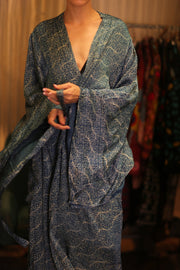 Person wearing a blue patterned robe with a blurred background